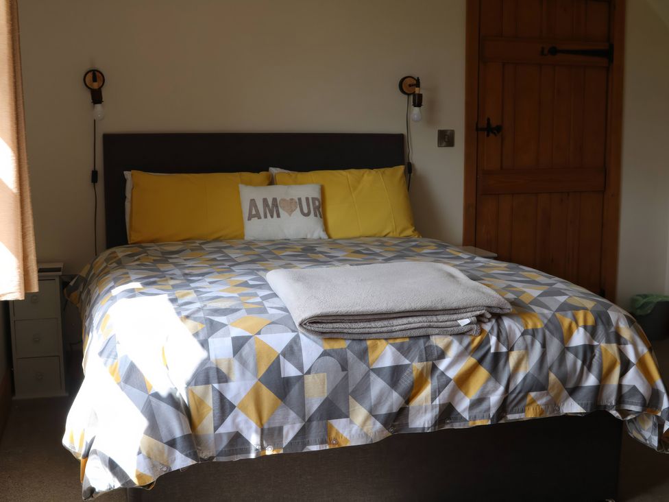 A bedroom with a bed and bedside lamps at Lake View Cottage Audley Brow near Market Drayton