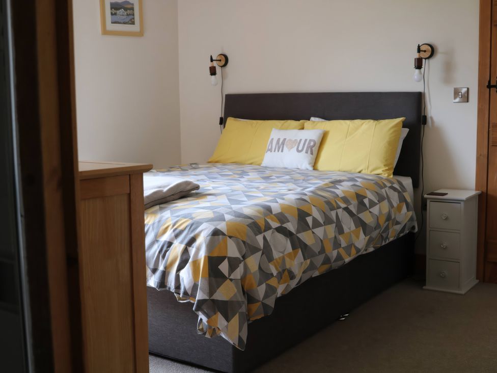 A bedroom with a bed and nightstand at Lake View Cottage in Audley Brow near Market Drayton