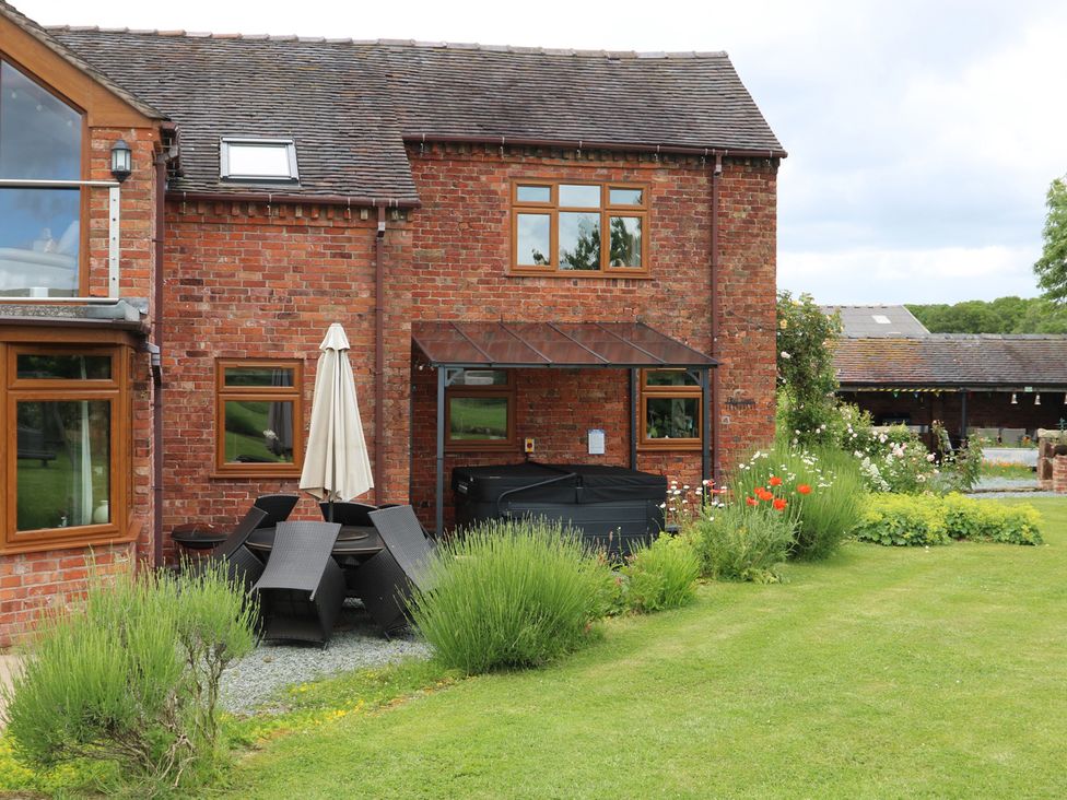 An outdoor area with patio furniture and garden at Lake View Cottage Audley Brow near Market Drayton