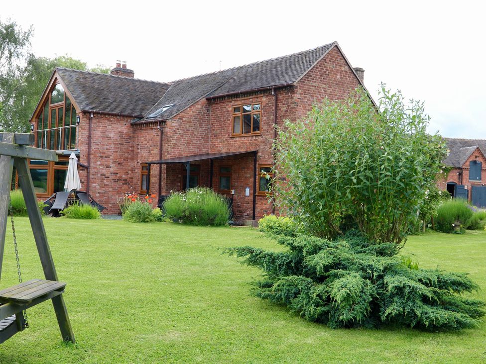 A garden with plants and a swing at Lake View Cottage Audley Brow near Market Drayton