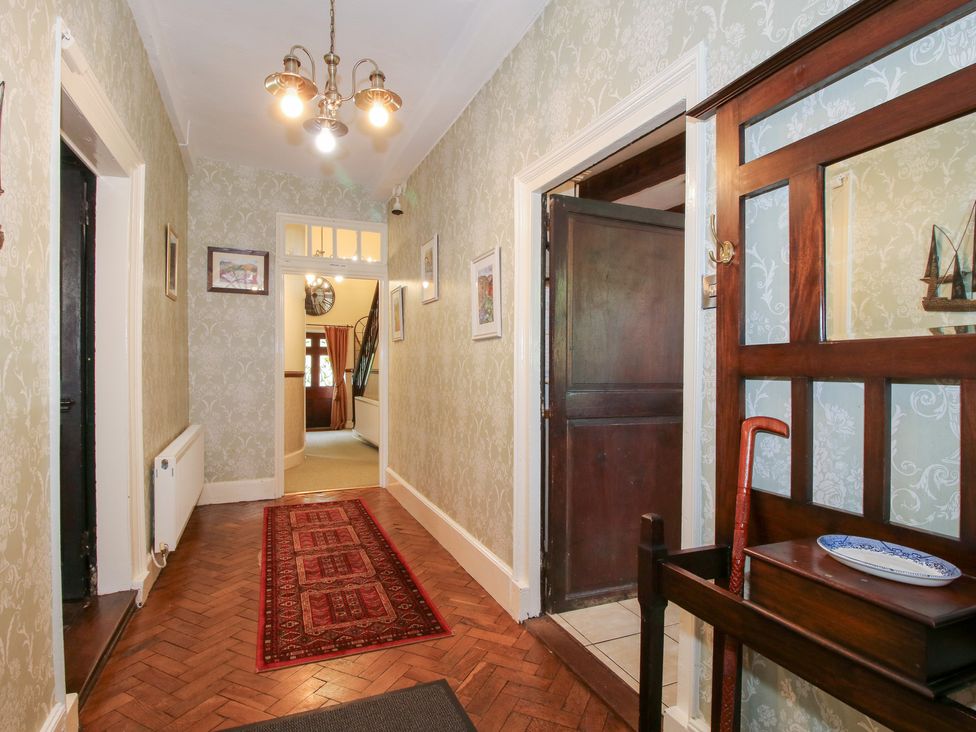 A hallway with framed pictures and a radiator at The Laurels in Bishop's Castle