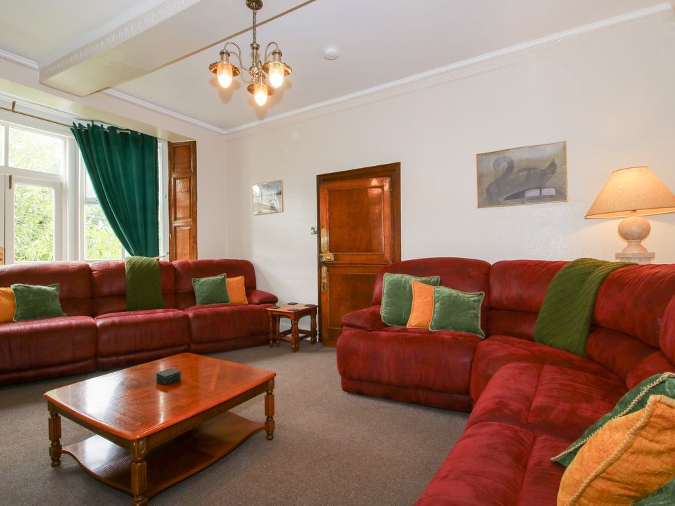A living room with a red sofa and coffee table at The Laurels in Bishop's Castle