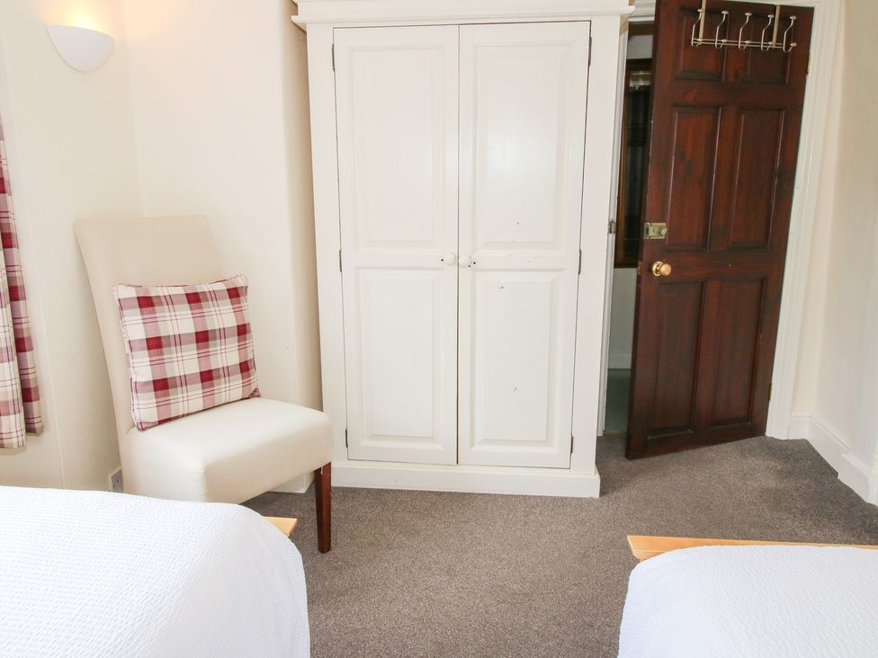 A bedroom with a wardrobe and chair at The Laurels in Bishop's Castle