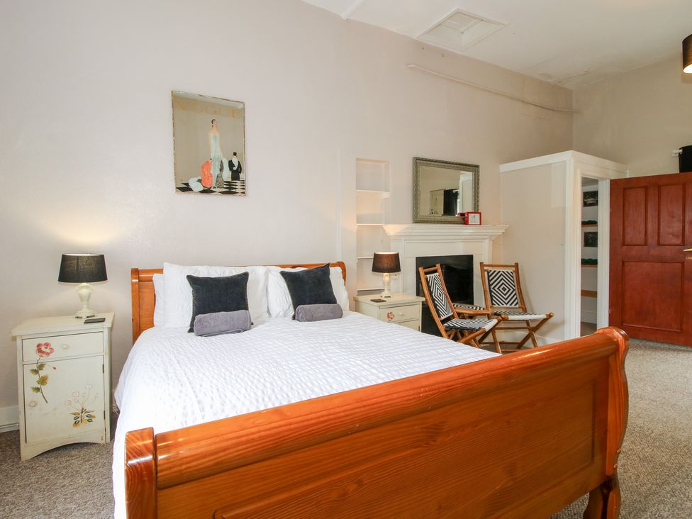 A bedroom with a bed, nightstand, and seating area at The Laurels in Bishop's Castle
