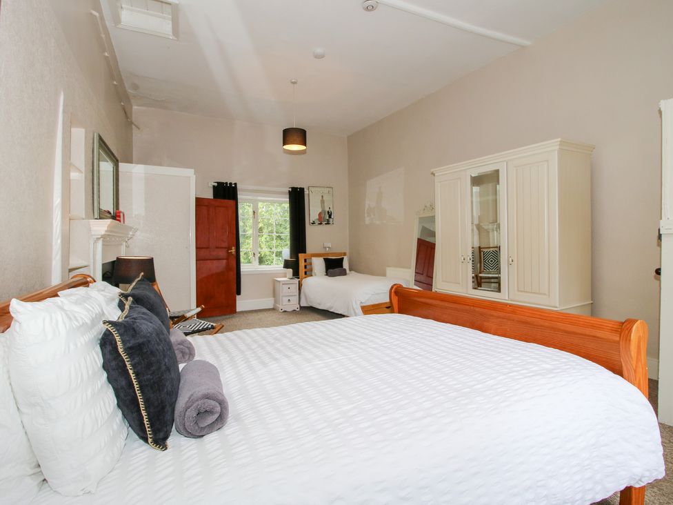 A bedroom with two beds and a wardrobe at The Laurels in Bishop's Castle