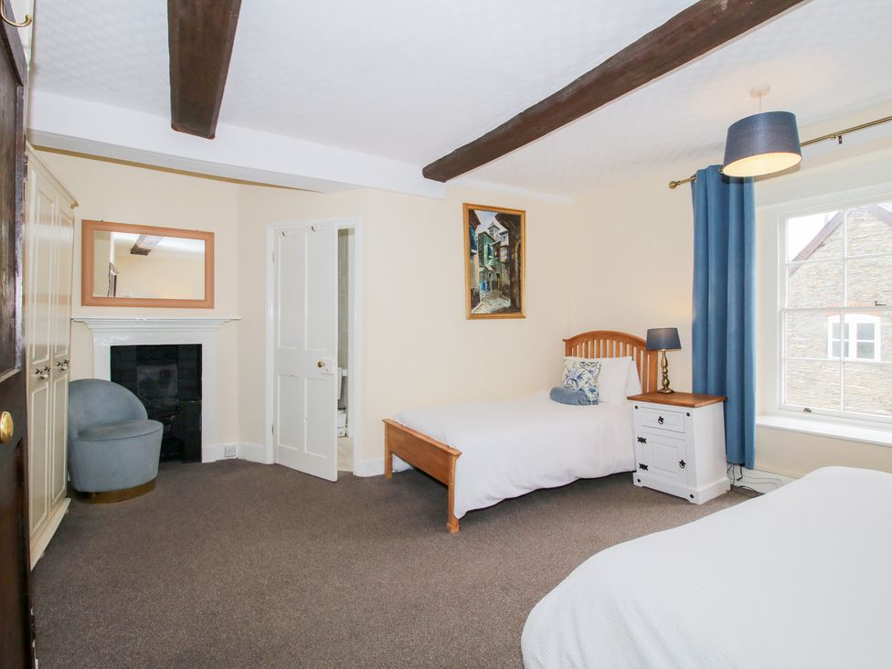 A bedroom with two beds and a chair at The Laurels in Bishop's Castle