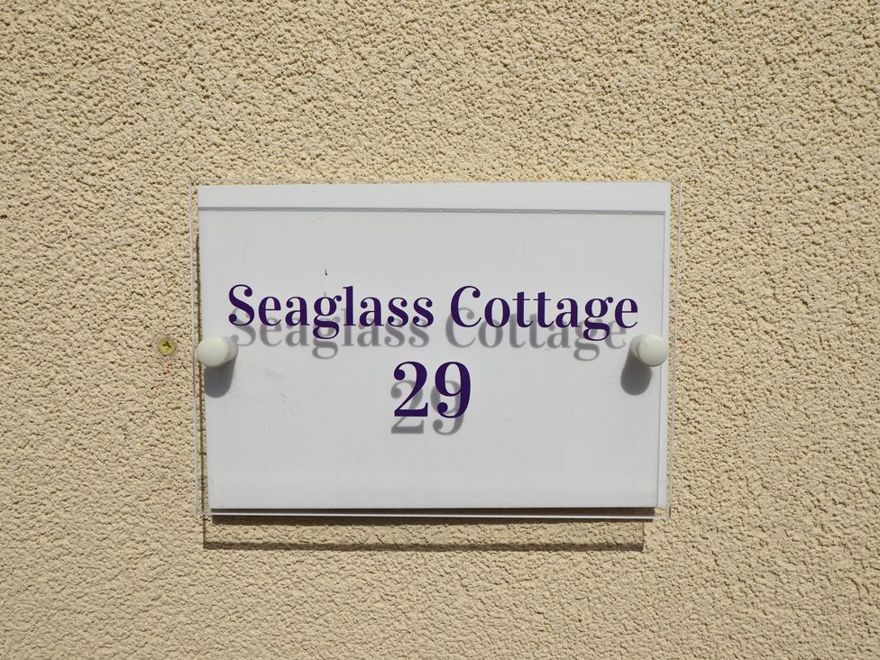A sign with 'Seaglass Cottage 29' on a wall at 29 High Street Aldeburgh
