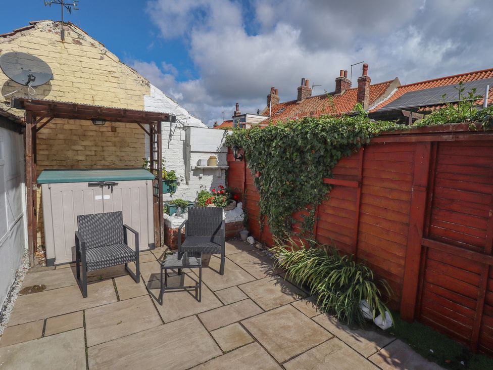 A garden with chairs and a storage container at 29 High Street in Aldeburgh