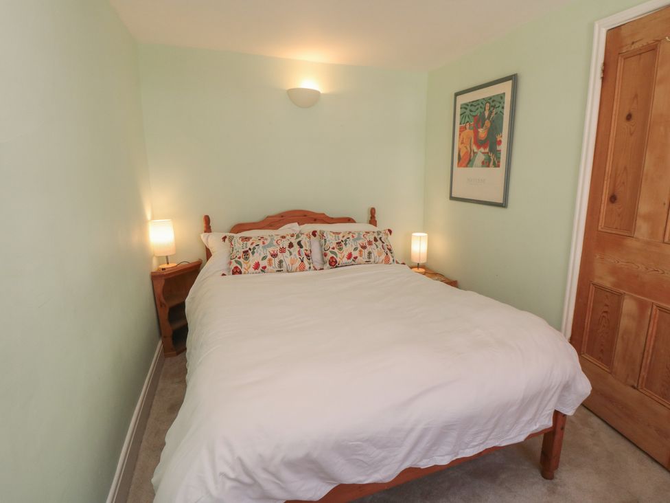 A bedroom with a bed and bedside lamps at Bulmers Cottage in Staithes