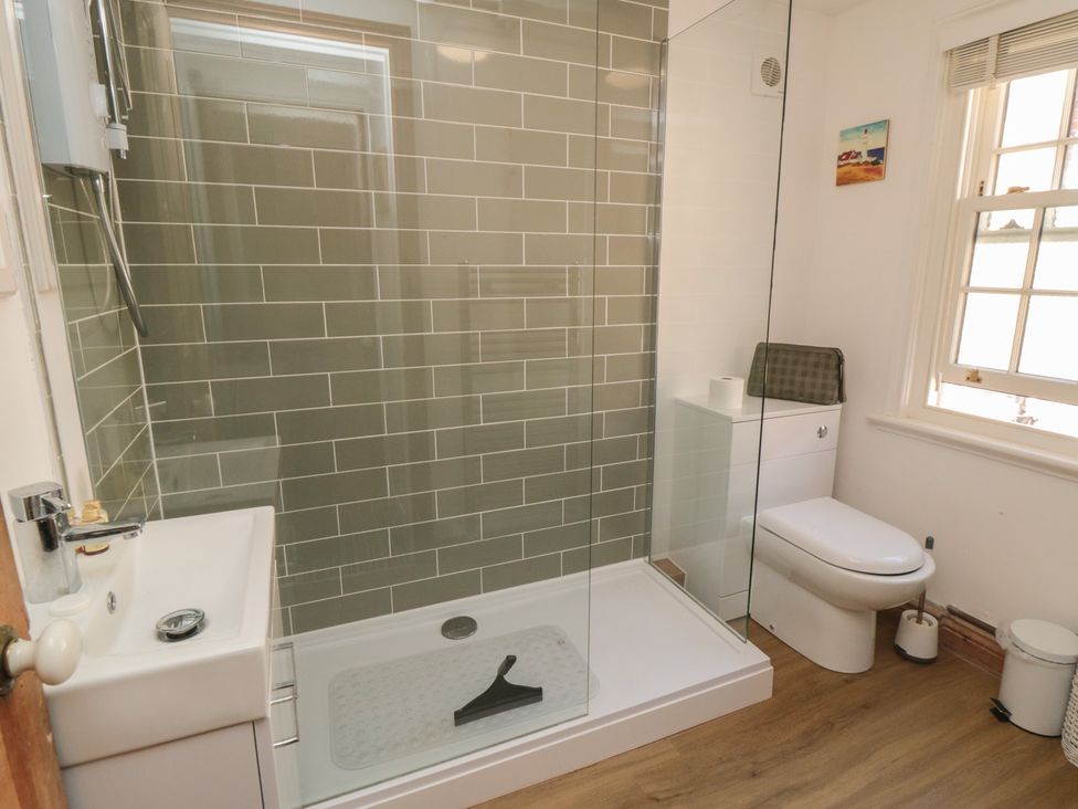 A bathroom with shower, toilet, and sink at Bulmers Cottage in Staithes