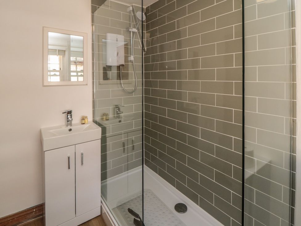 A bathroom with a shower and sink at Bulmers Cottage in Staithes