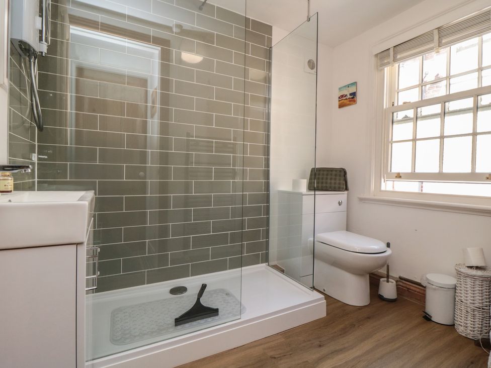 A bathroom with a shower and toilet at Bulmers Cottage in Staithes