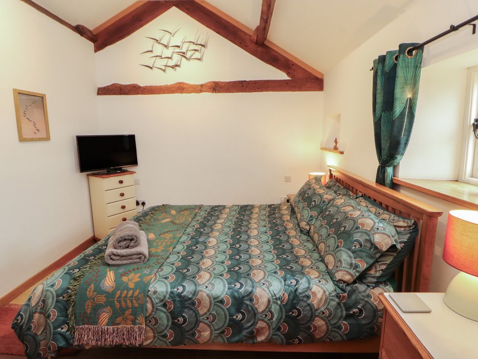 A bedroom with a bed and television at Sonya's Cottage Anthorn, Solway Firth