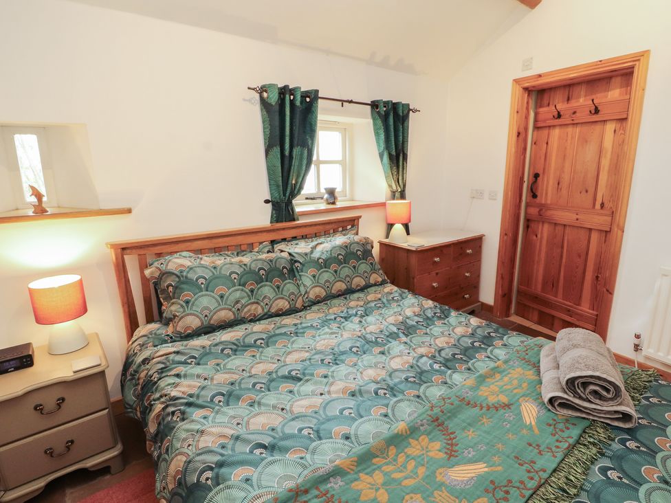A bedroom with a bed and nightstand at Sonya's Cottage Anthorn, Solway Firth
