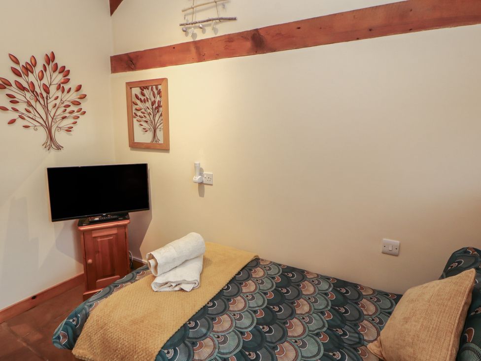 A bedroom with a bed and tv at Sonya's Cottage Anthorn, Solway Firth