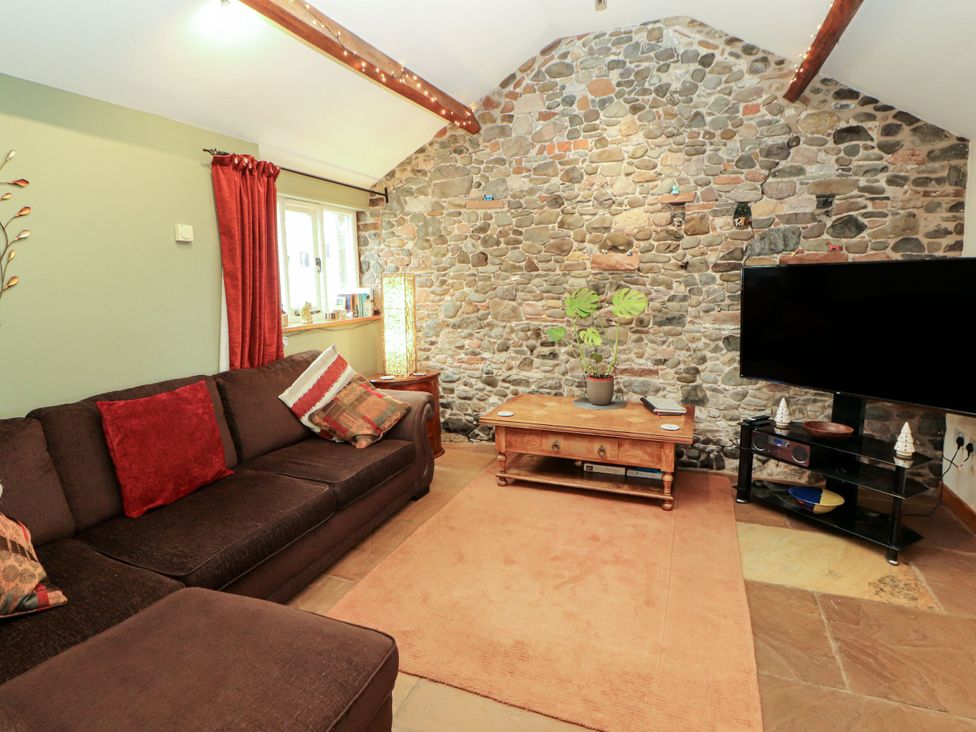 A living room with a sofa and television at Sonya's Cottage in Anthorn, Solway Firth