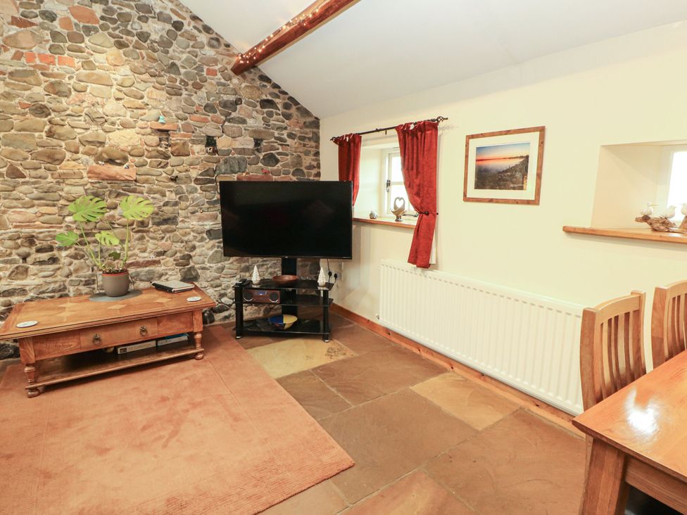 A living room with a television and coffee table at Sonya's Cottage in Anthorn, Solway Firth