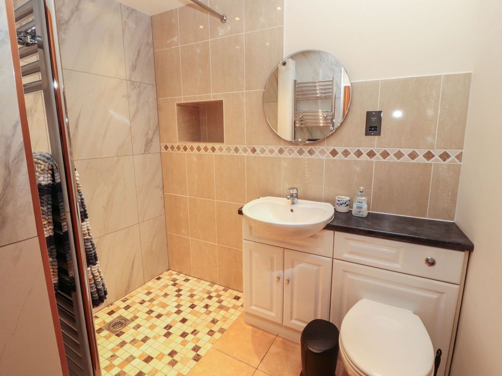 A bathroom with a shower, sink, and toilet at Sonya's Cottage in Anthorn, Solway Firth