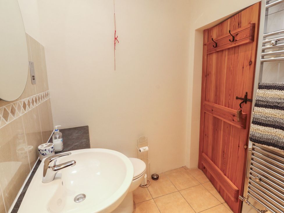 A bathroom with a bath and toilet at Sonya's Cottage in Anthorn, Solway Firth