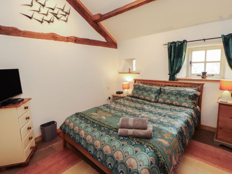 A bedroom with a bed and television at Sonya's Cottage Anthorn, Solway Firth