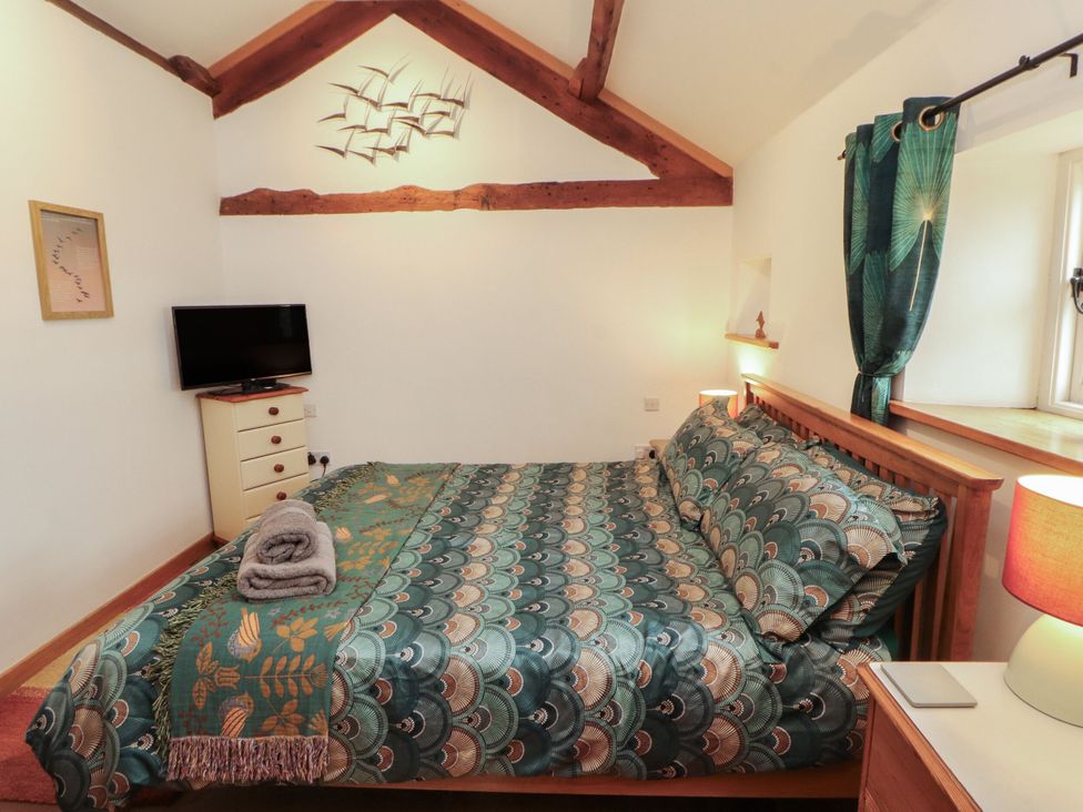 A bedroom with a bed, television, and dresser at Sonya's Cottage Anthorn, Solway Firth