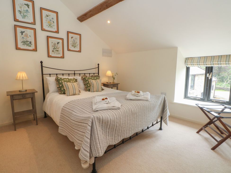 A bedroom with a bed and bedside table at The Hayloft in Northop near Chester