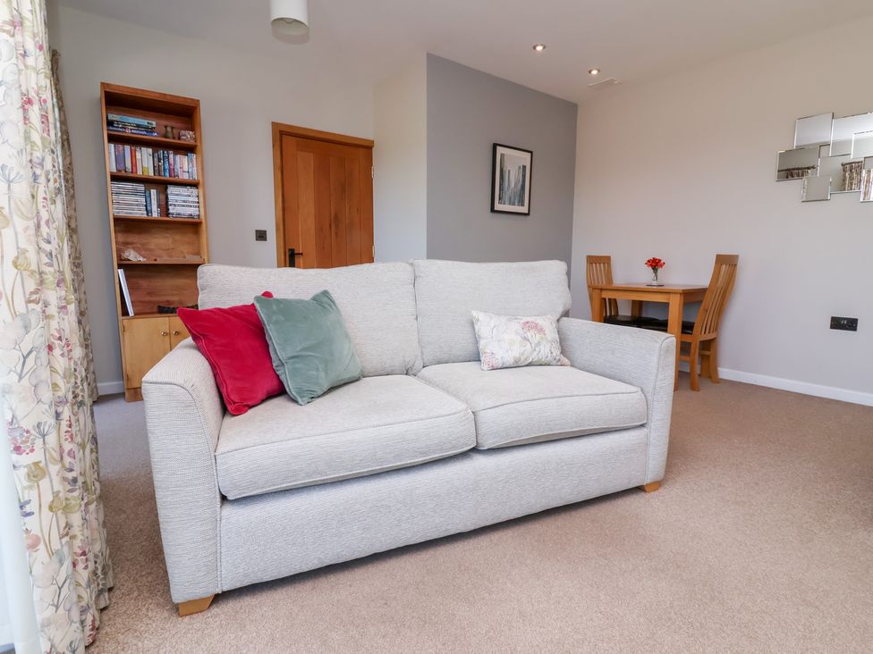 A living room with a sofa and dining table at Pound Cottage in Huntshaw near Great Torrington