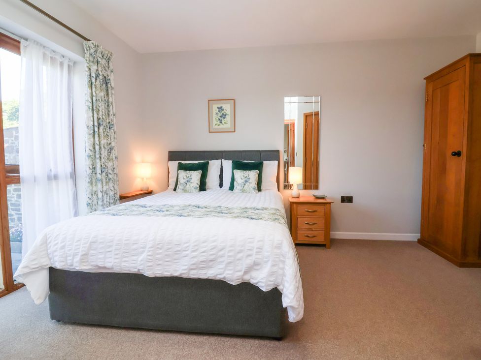A bedroom with a bed and lamp at Pound Cottage in Huntshaw near Great Torrington