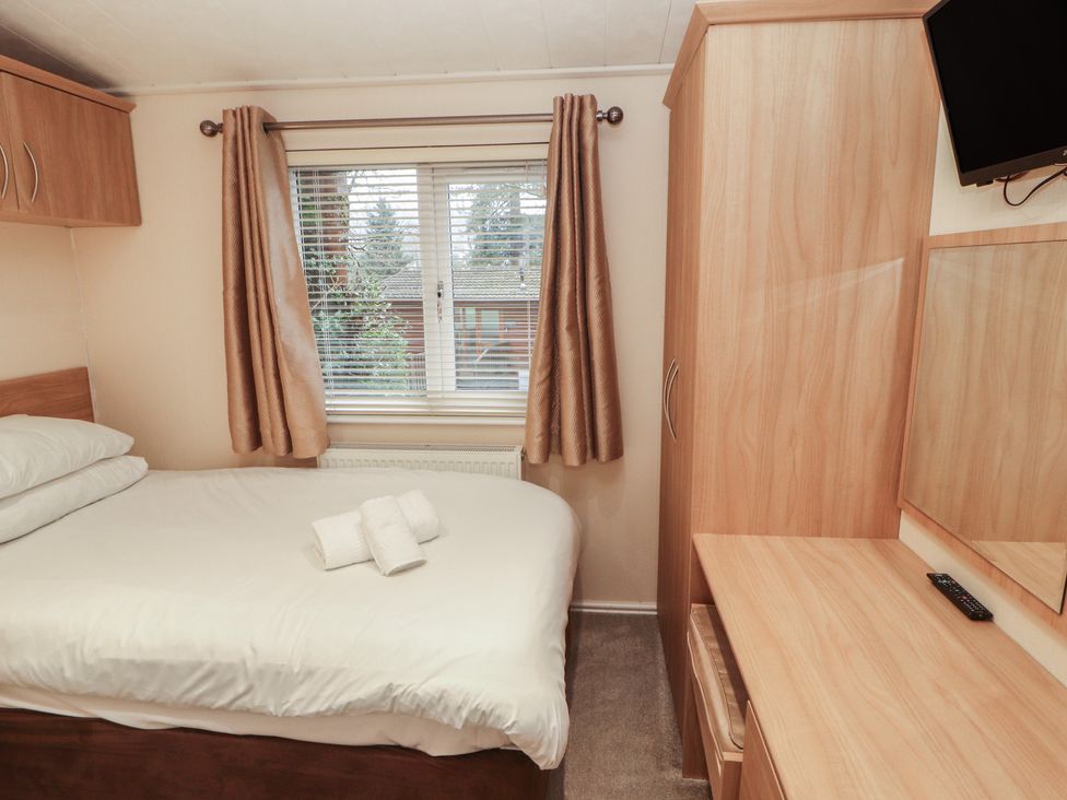 A bedroom with a bed and wardrobe at Beech Hill Lodge (Beech Hill 9) at Fallbarrow Park, Bowness-on-Windermere