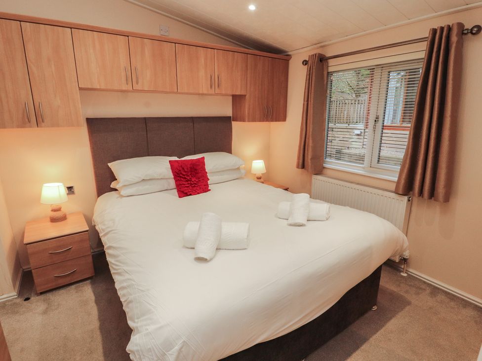 A bedroom with a bed and bedside table at Beech Hill Lodge (Beech Hill 9) at Fallbarrow Park, Bowness-on-Windermere