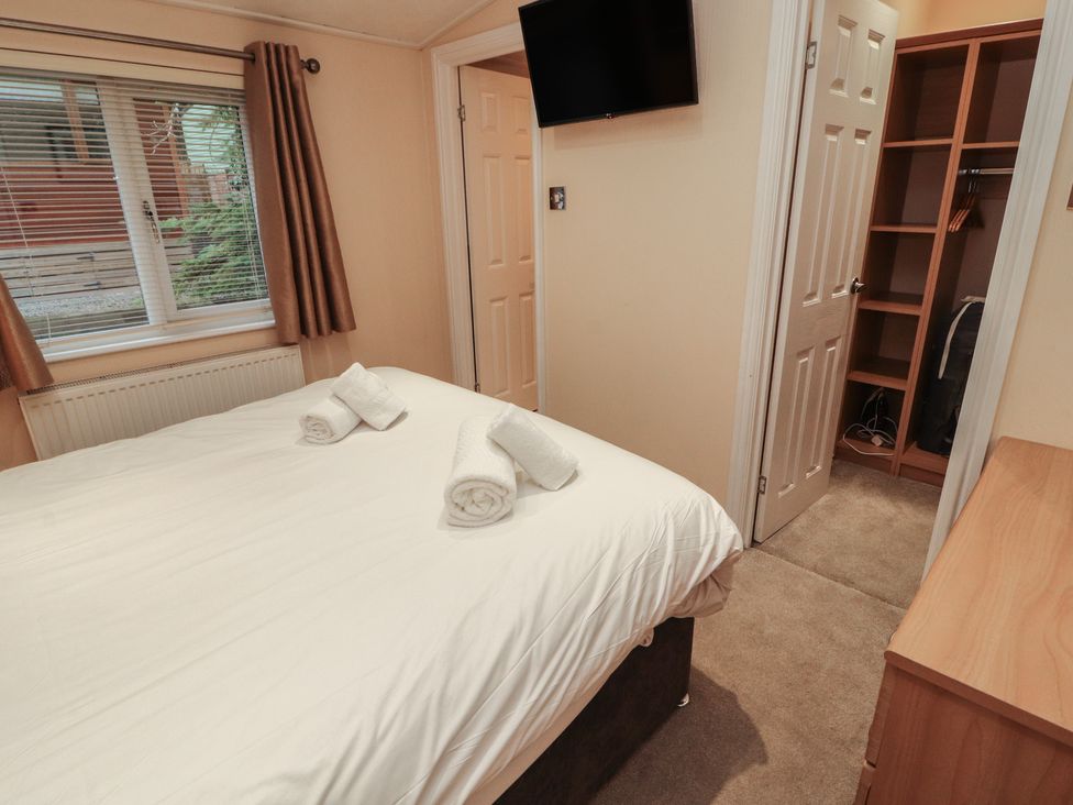 A bedroom with a bed and television at Beech Hill Lodge (Beech Hill 9) at Fallbarrow Park, Bowness-on-Windermere