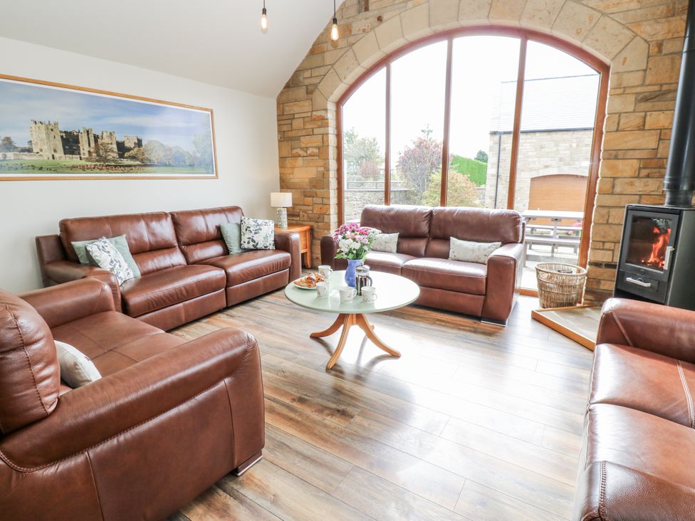 A living room with brown sofas and a table at Jacob's Lodge in Eggleston