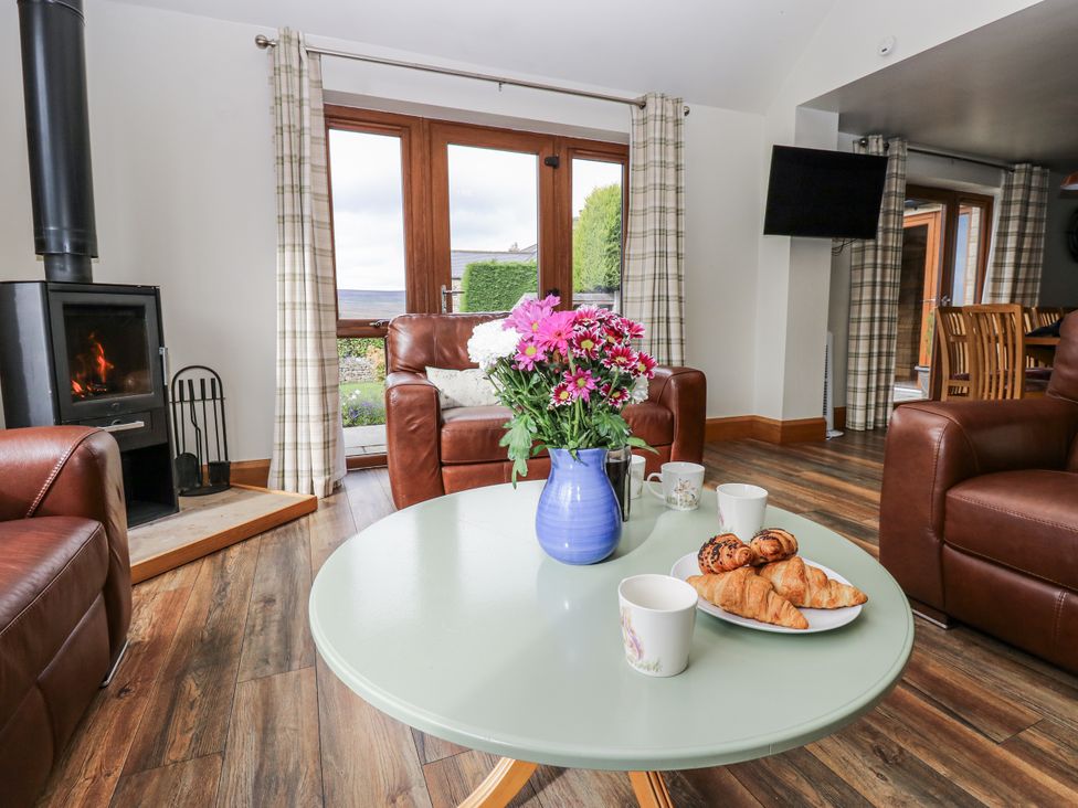 A living room with a coffee table and flowers at Jacob's Lodge in Eggleston