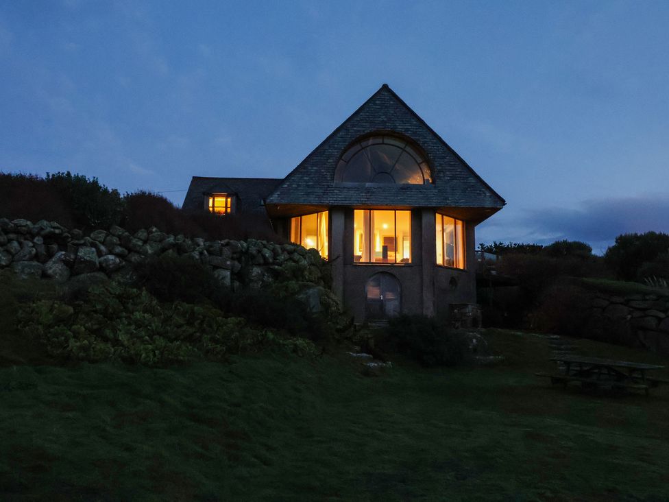A house with windows illuminated at Cragford in Sennen Cove