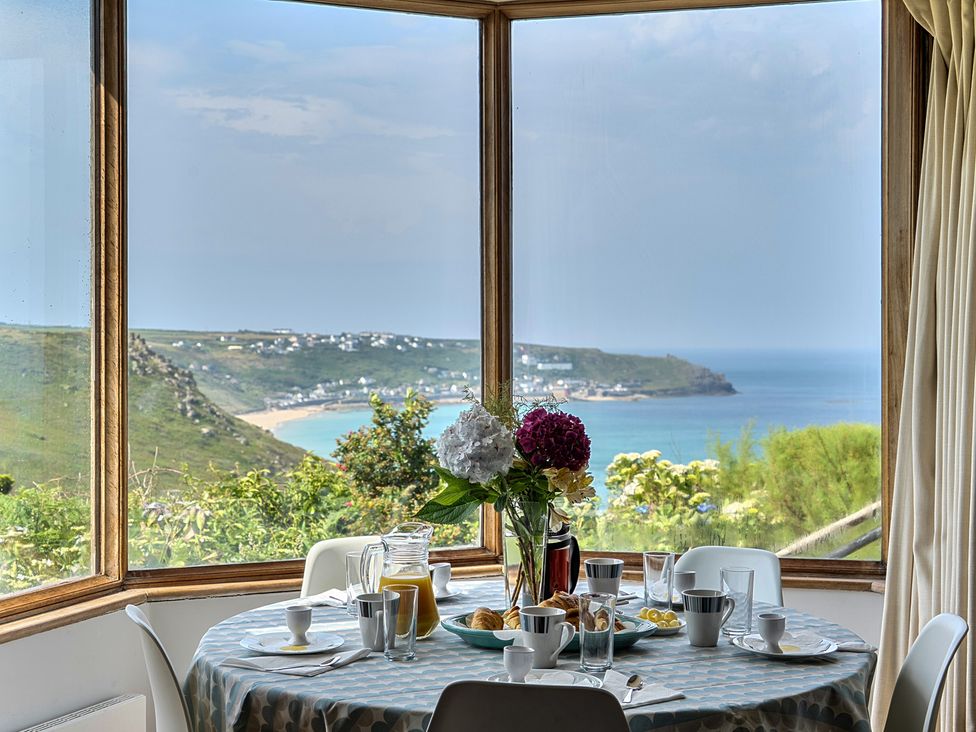 A dining room with a table set for breakfast at Cragford in Sennen Cove
