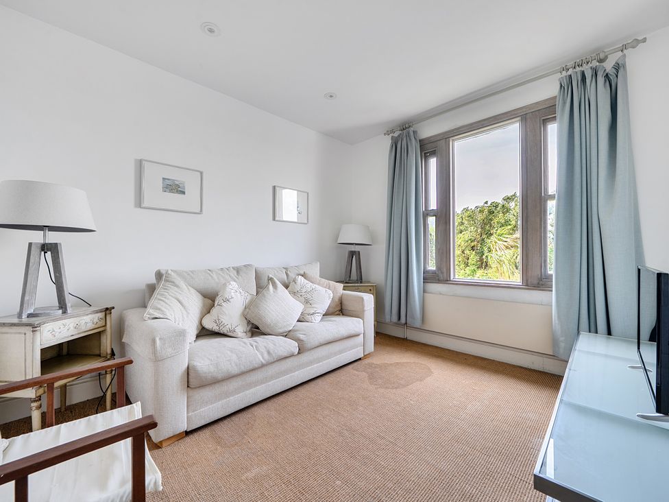 A living room with a sofa and lamp at Cragford in Sennen Cove