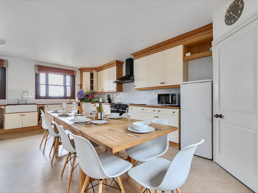 A kitchen with a dining table and chairs at Cragford Sennen Cove