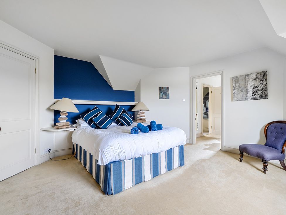 A bedroom with a bed and chair at Cragford Sennen Cove