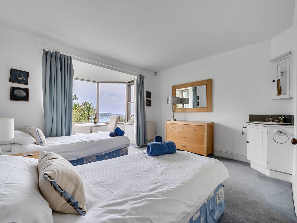 A bedroom with two beds and a dresser at Cragford Sennen Cove