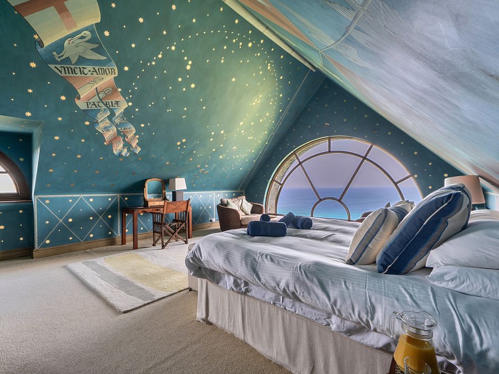 A bedroom with a bed and large window at Cragford in Sennen Cove
