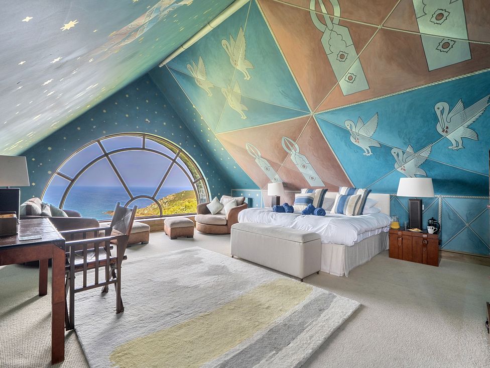 A bedroom with a large window and sea view at Cragford in Sennen Cove
