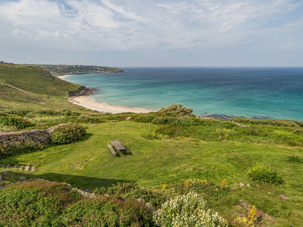 A beach and ocean view with a picnic table at Cragford in Sennen Cove