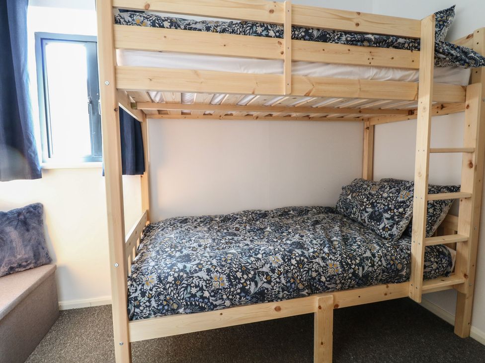 A bunk bed with floral bedding in a bedroom at The Long Barn near Morton on the Hill