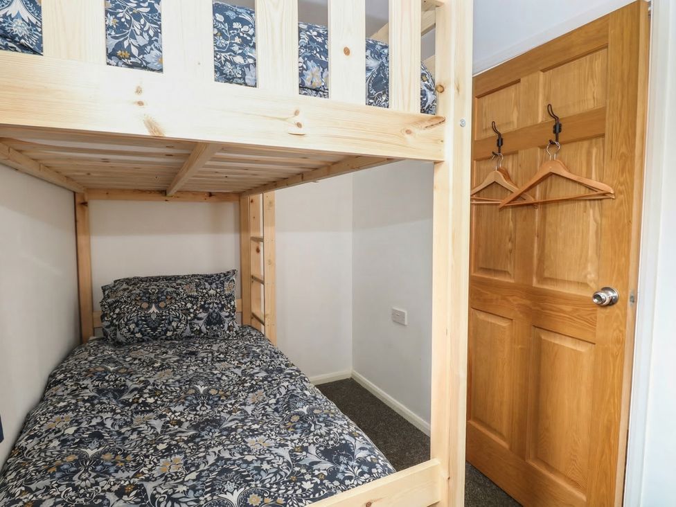 A bedroom with a bunk bed and door at The Long Barn near Morton on the Hill