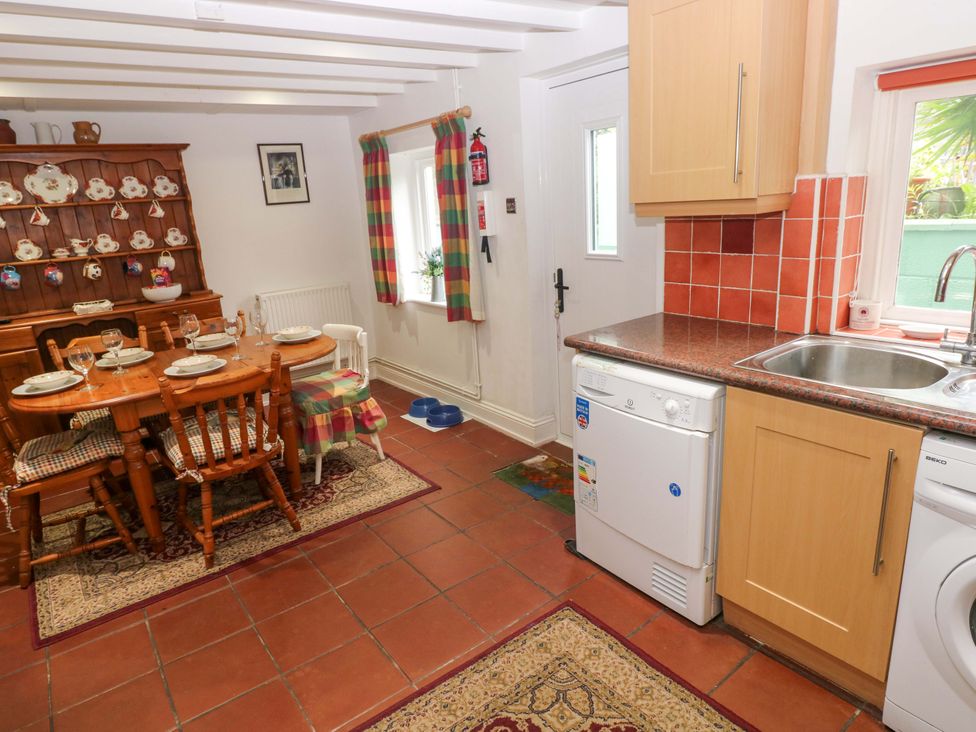 A kitchen with a dining area and a dishwasher at Milk Wood Cottage in Laugharne