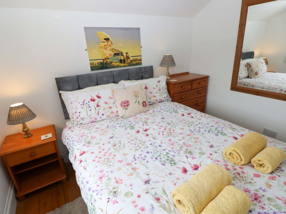 A bedroom with a double bed and nightstand lamps at Milk Wood Cottage in Laugharne