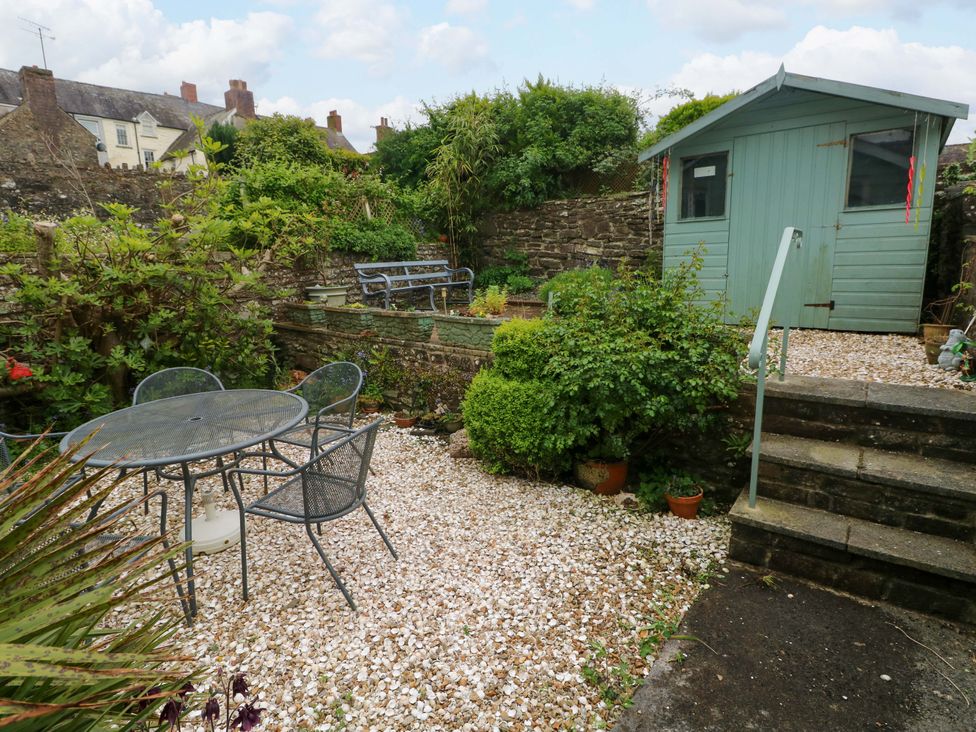A garden with a table and chairs at Milk Wood Cottage in Laugharne