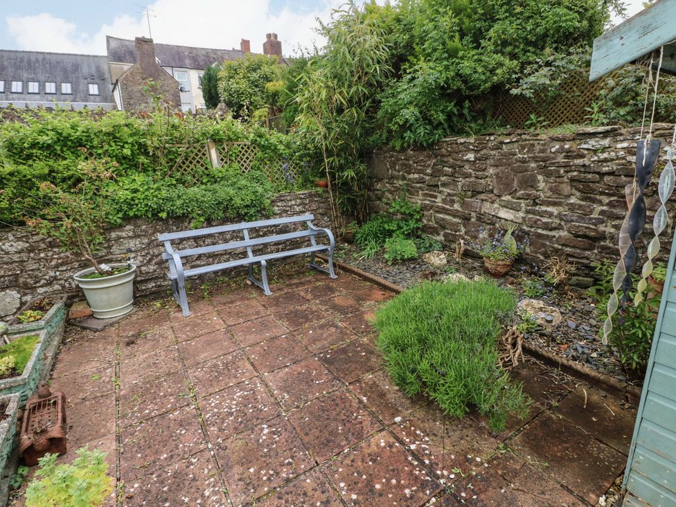 A garden with a bench and plants at Milk Wood Cottage in Laugharne
