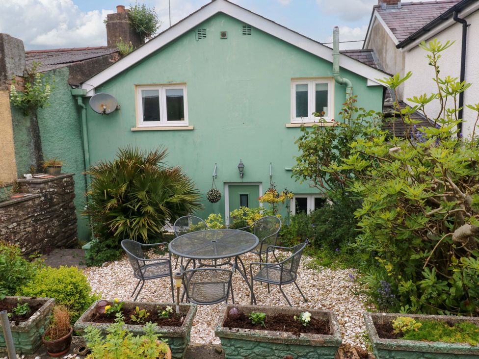 A garden area with a table and chairs at Milk Wood Cottage in Laugharne