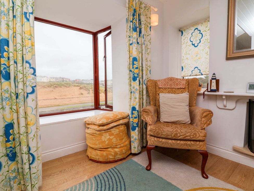 A living room with a chair and window view at The Fort in Bude